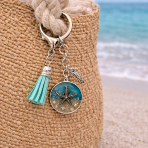 Isle of Wight resin keyring with real beach sand, starfish charm, seahorse and turquoise tassel shown on beach bag