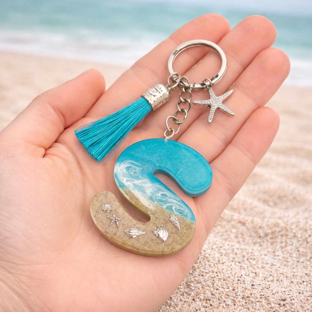 Isle of Wight handmade resin letter S keyring held in hand showing size detail with beach wave design