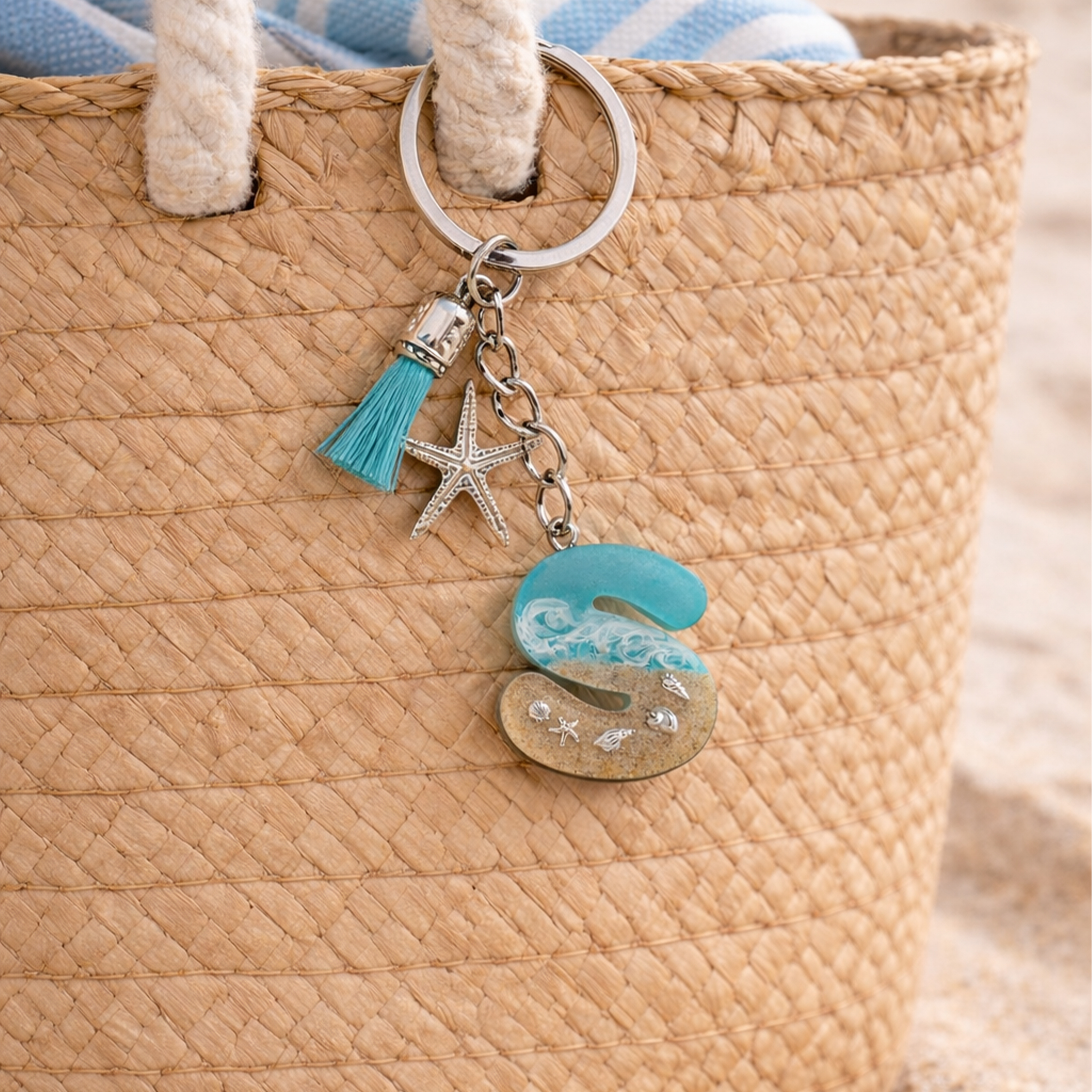 Isle of Wight resin letter S keyring hanging on straw beach bag with turquoise tassel and starfish charm