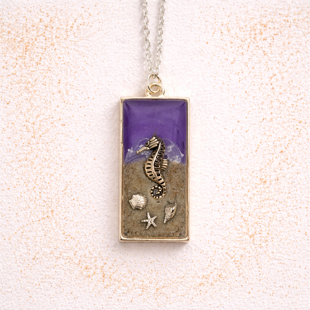 Purple resin seahorse necklace with Isle of Wight sand and shell charms on silver chain.