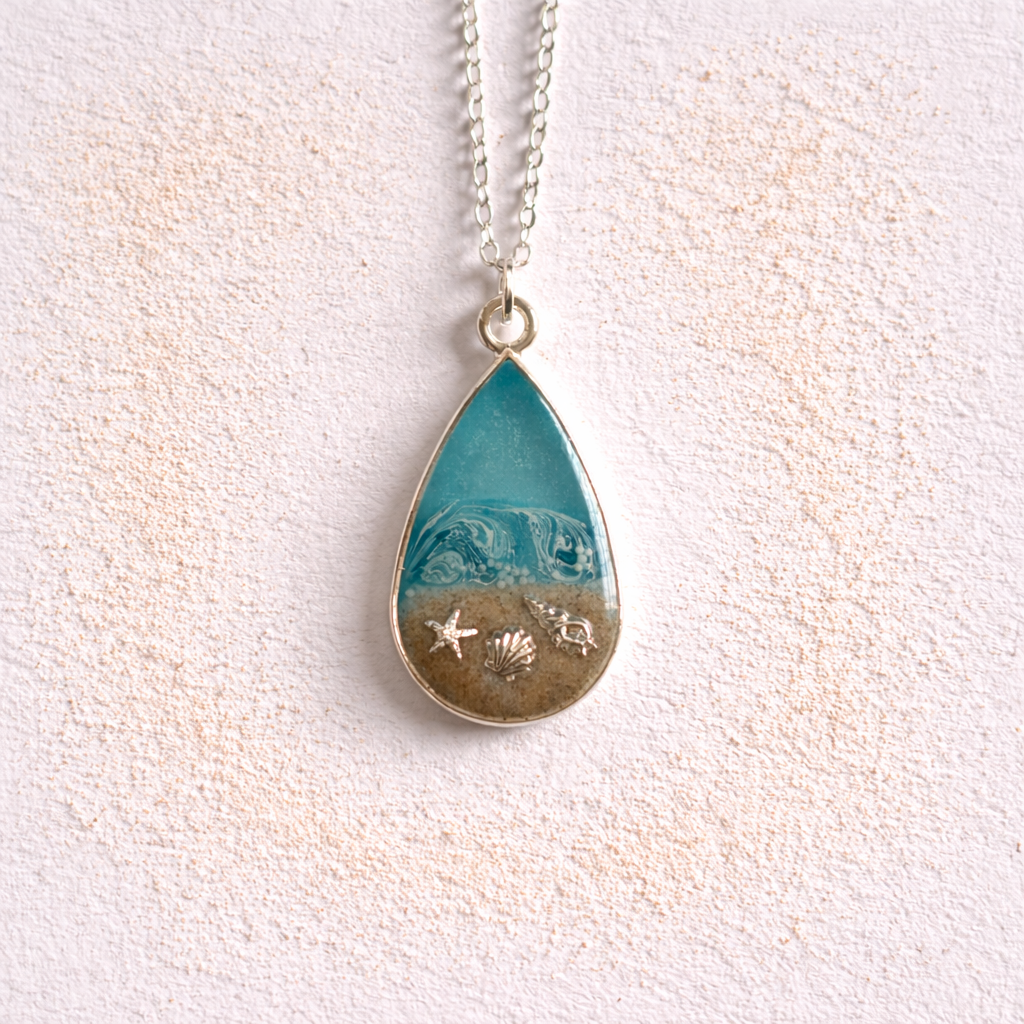 Turquoise resin teardrop necklace with Isle of Wight sand and shell charms on silver chain.