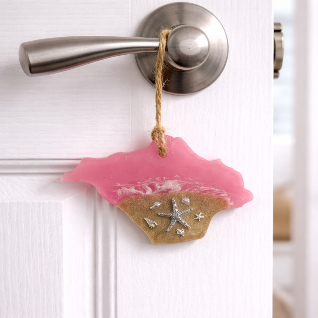 Handmade Isle of Wight resin ornament with beach sand and silver starfish hanging from a door handle.