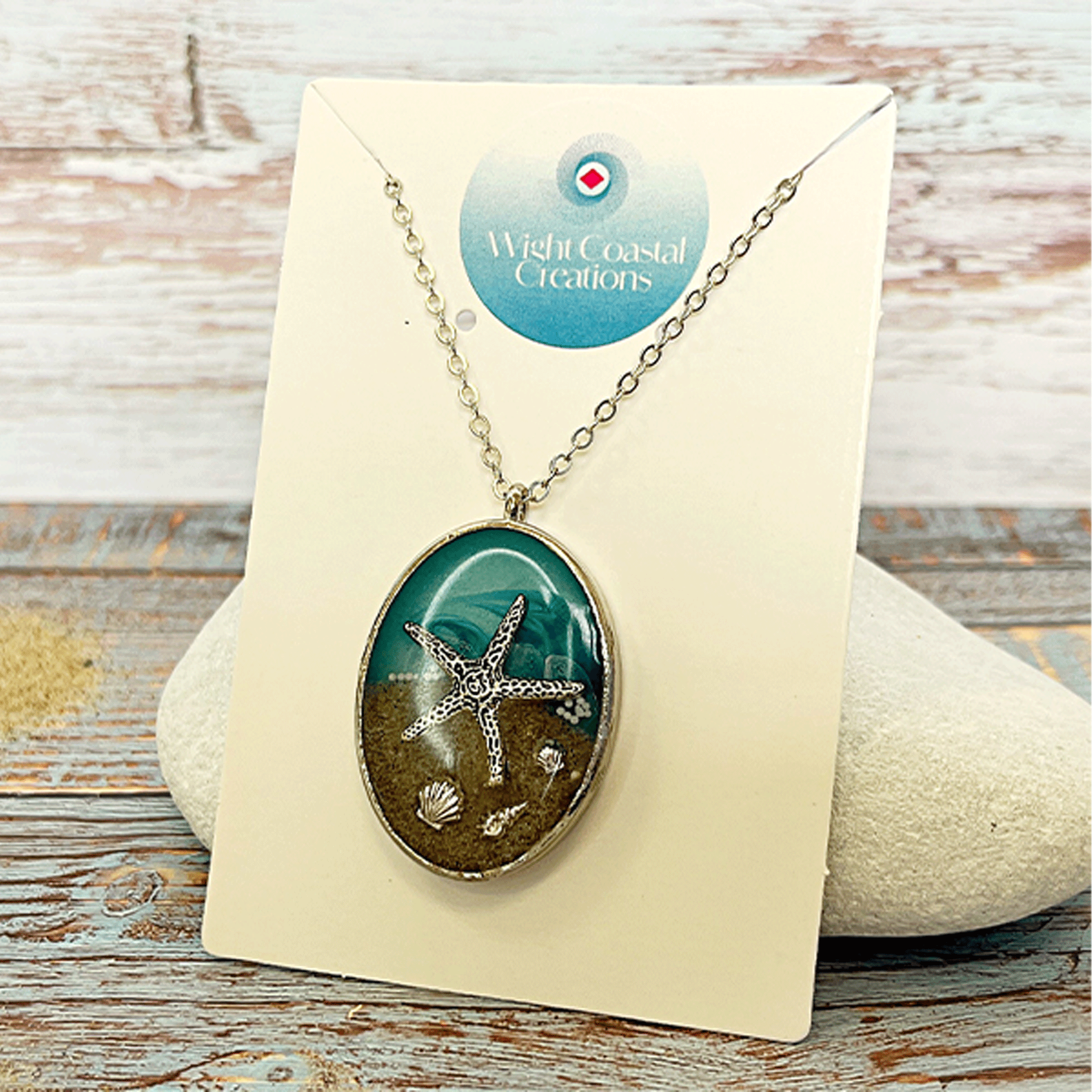 Isle of Wight starfish pendant necklace with resin, sand and silver charm on a linen background