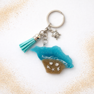 Isle of Wight keyring with turquoise sea, real sand, and silver seashell charms on white background
