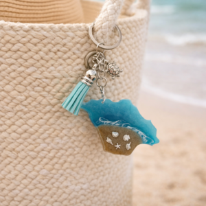Isle of Wight resin keyring hanging from beach bag with coastal design and turquoise tassel.