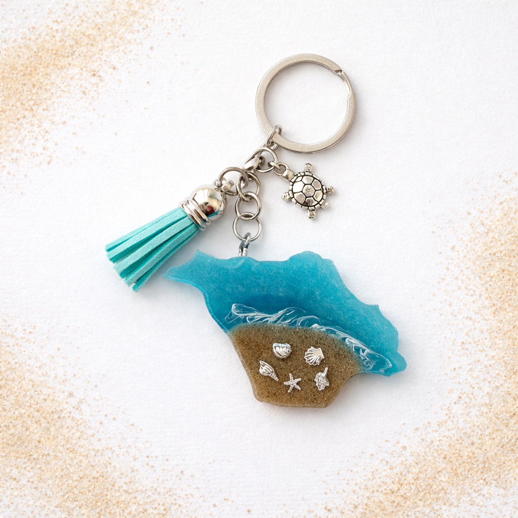 Isle of Wight keyring with turquoise sea, real sand, and silver seashell charms on white background