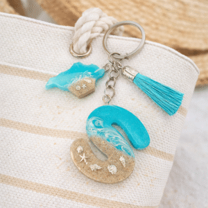 Isle of Wight resin letter S keyring hanging on straw beach bag with turquoise tassel and starfish charm