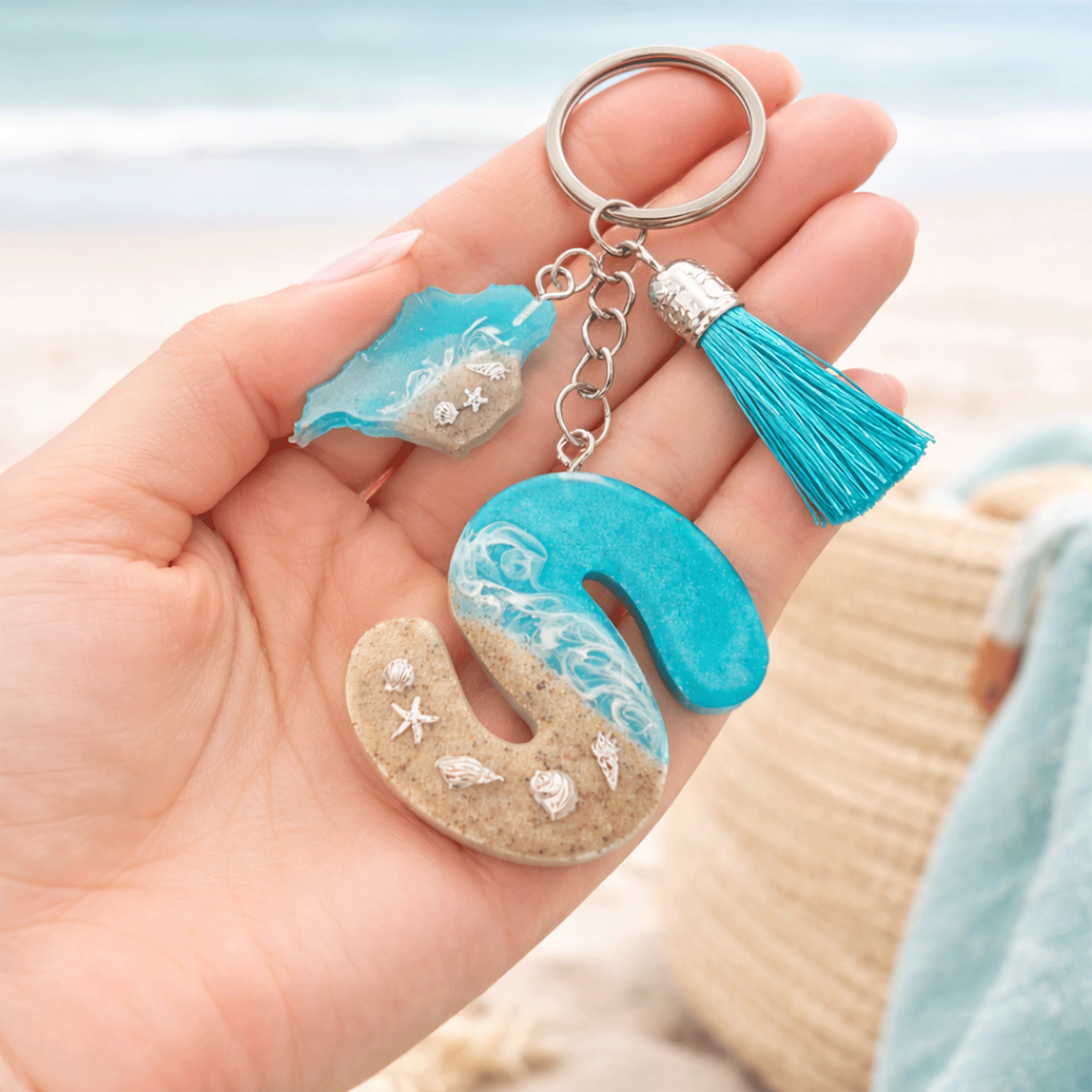 Isle of Wight handmade resin letter S keyring held in hand showing size detail with beach wave design