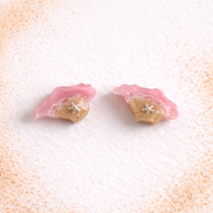 Isle of Wight resin stud earrings in pink with real sand and silver starfish on white background
