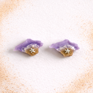 Isle of Wight resin stud earrings in purple with real sand and silver starfish on white background