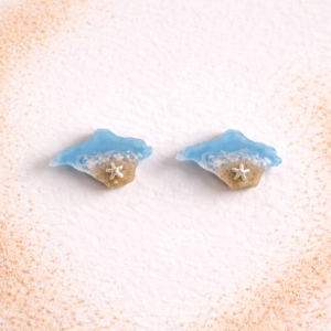Isle of Wight resin stud earrings in turquoise with real sand and silver starfish on white background